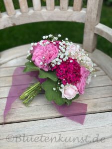 zeigt pink Brautstrauss mit Rosen