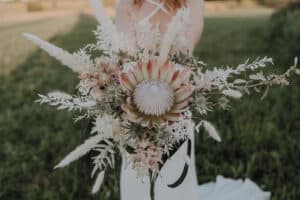 Hochzeitsfloristik vintage brautstrauss boho mit Königs Protea , pampasgrass , disteln, olive im Hintergrund Bohobrautkleid - florist für freie Hochzeit ingolstadt