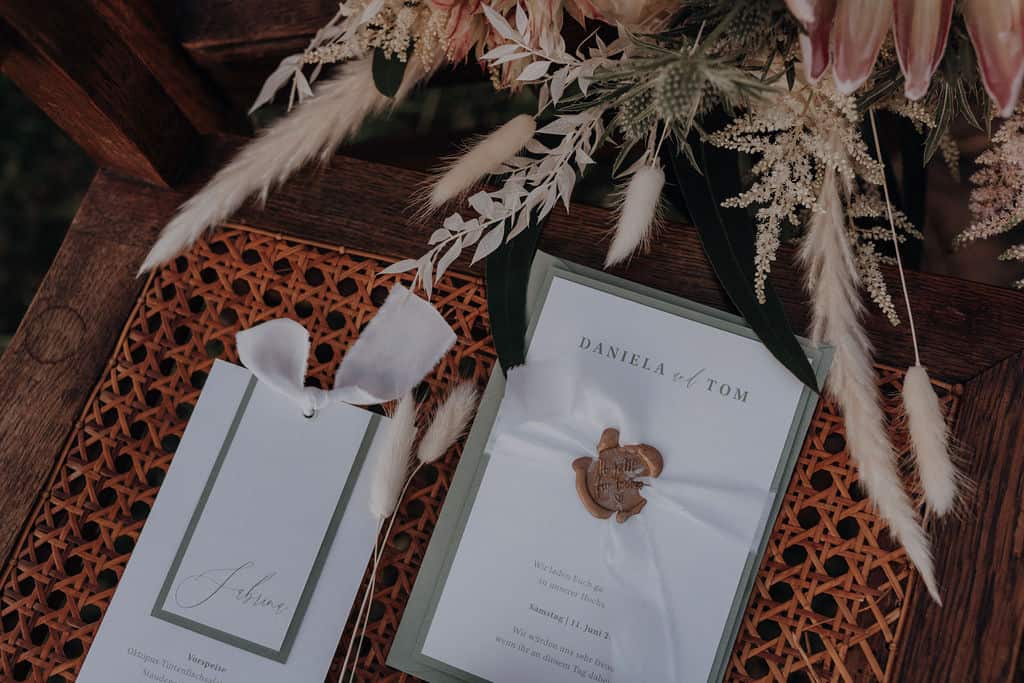 Einladungskarte und Tisckarte für Hochzeit von Daniela und Tom - handgemachte Papeterie für Traumhochzeit auf vintag möbel mit Trockenblumenstrauß